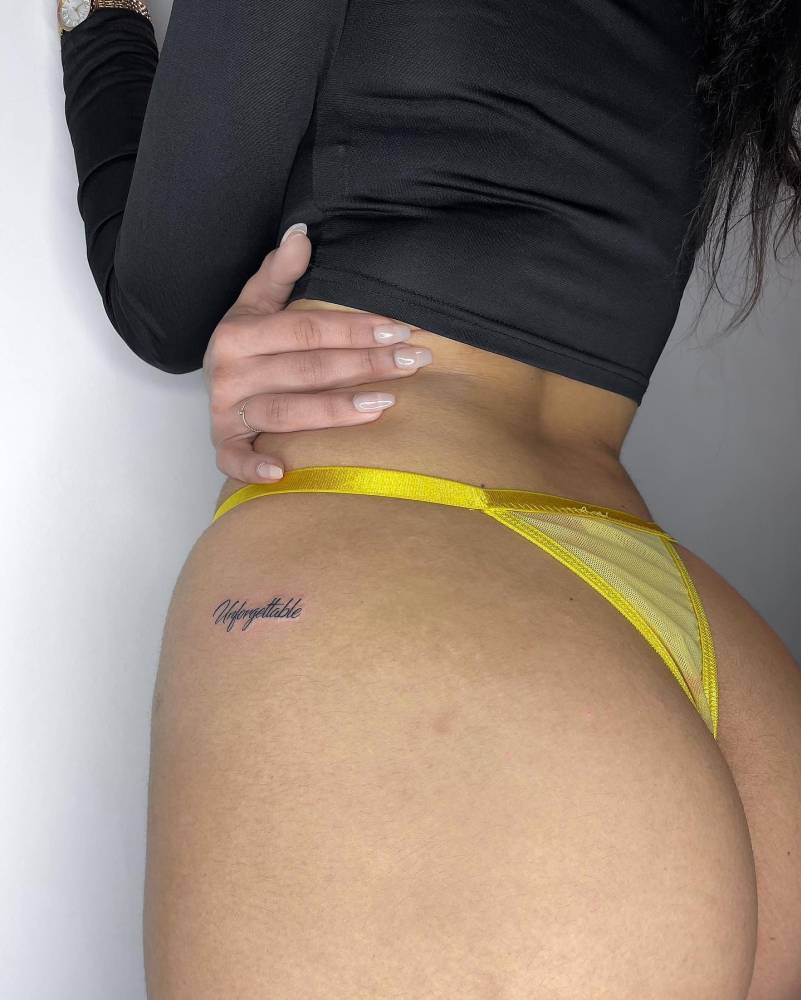 Tattoo of the word "unforgettable" done on the hip.