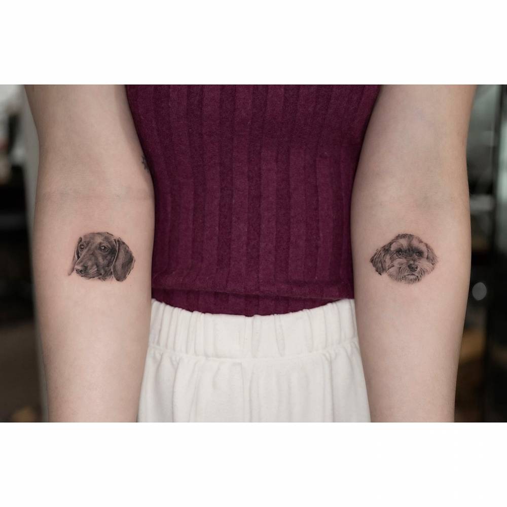 Individual matching dog portraits tattooed on the inner forearm.