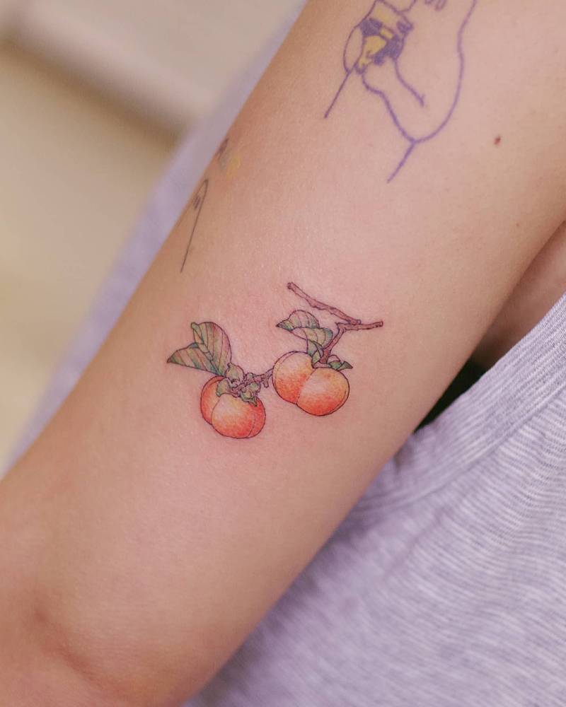 Peaches tattoo in illustrative style placed on the tricep.