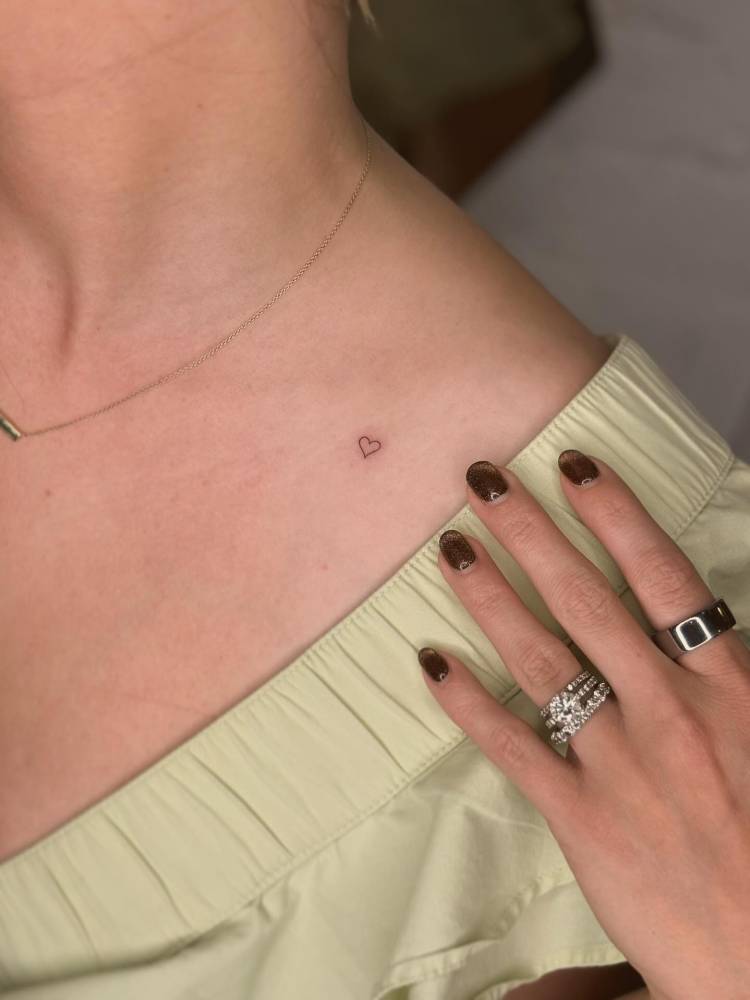 Minimalistic micro heart tattoo done on the collarbone.