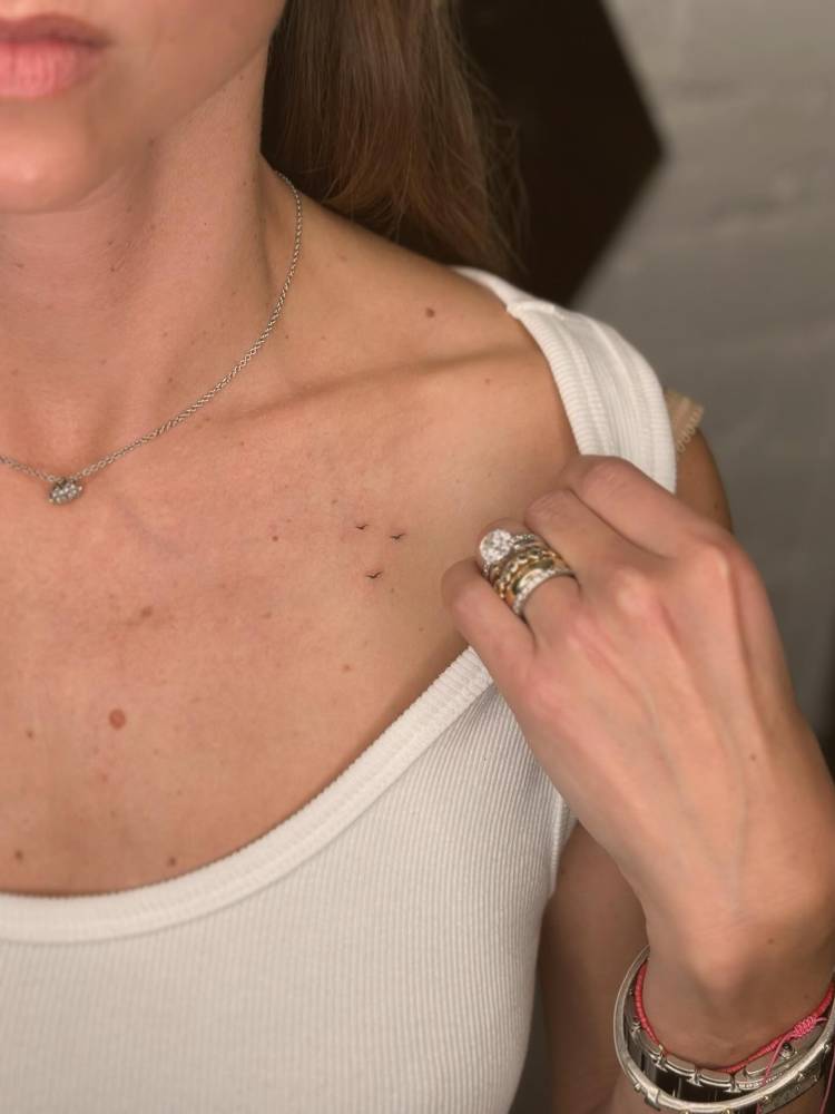 Minimalistic little flying birds tattoo located on the chest.