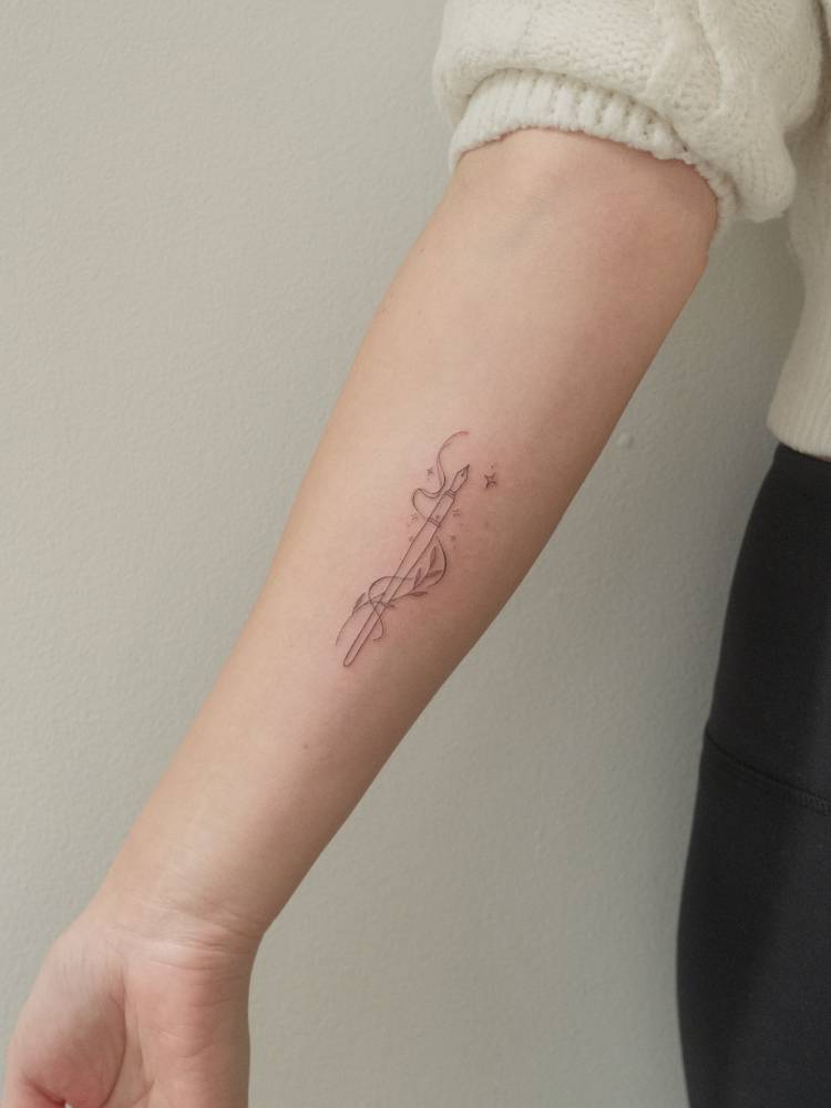 Pen tattoo in fine line style placed on the inner forearm.