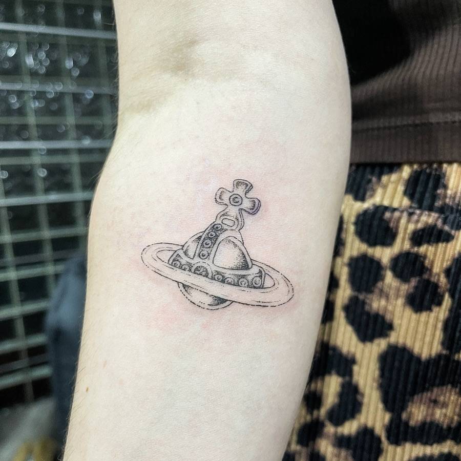 Vivienne Westwood orb tattoo in illustrative style placed on the inner forearm.