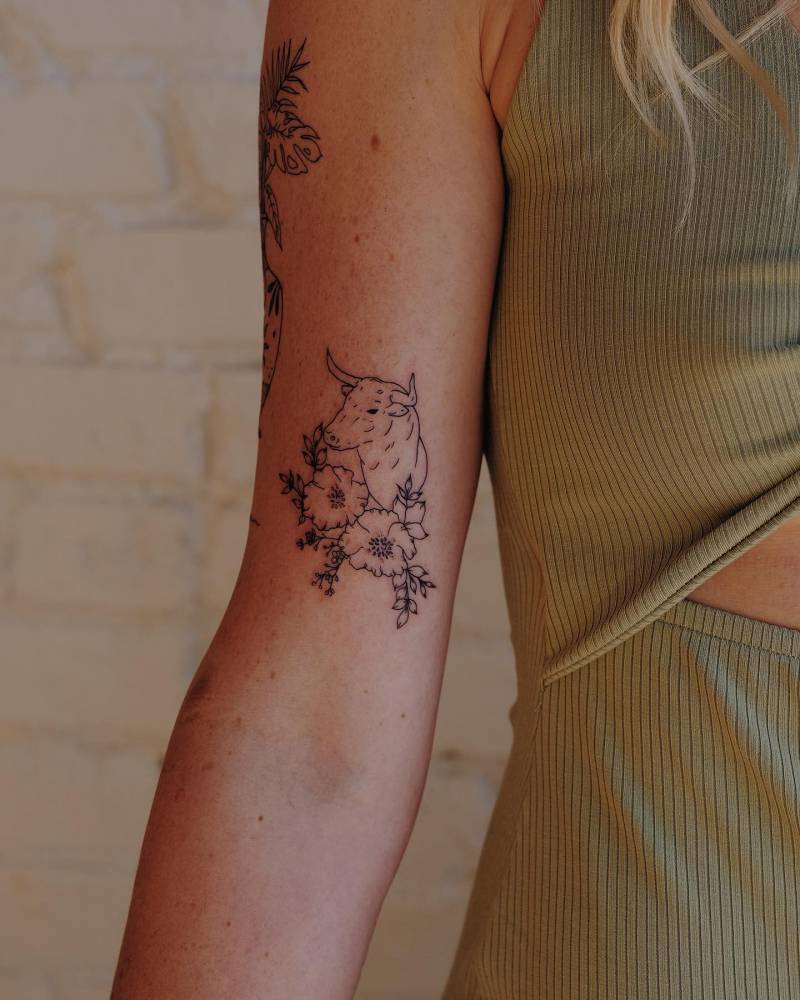 Bull portrait tattoo located on the bicep.
