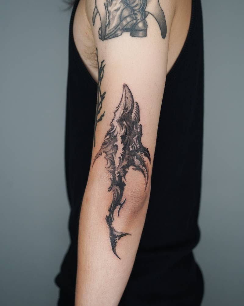 Abstract style shark tattoo located on the elbow.