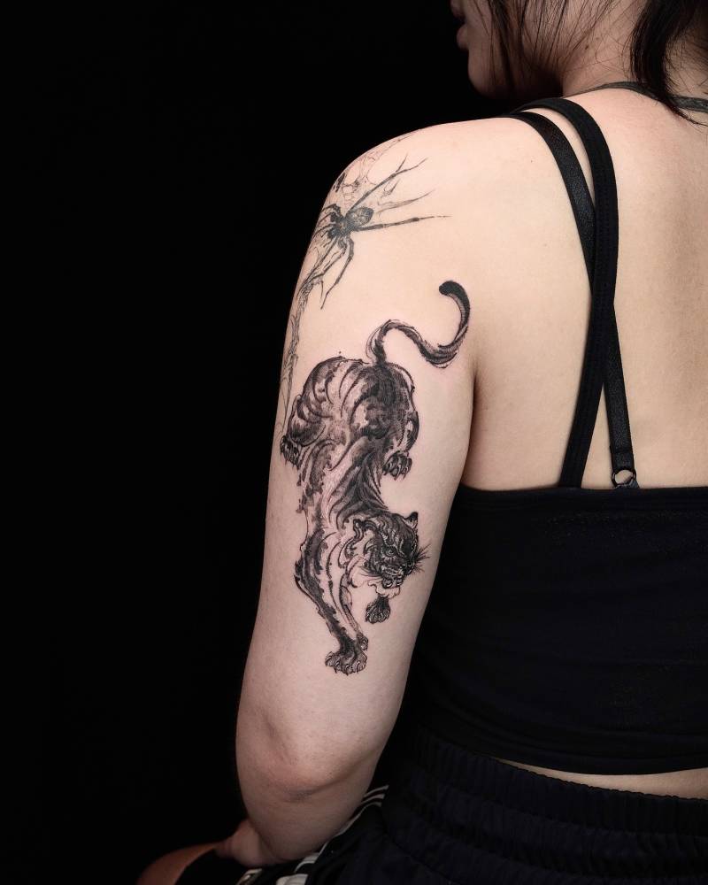 Tiger tattoo in blackwork style located on the tricep.