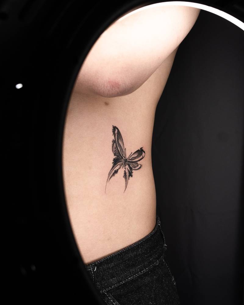 Watercolor style butterfly tattoo done on the waist.