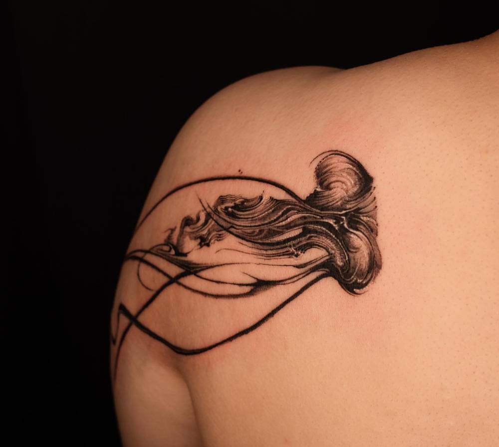 Jellyfish tattoo located on the shoulder blade, blackwork style.