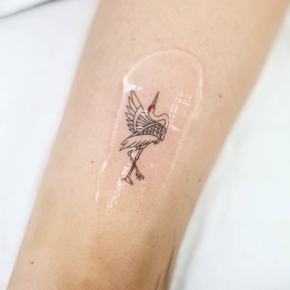 Red crowned crane tattoo located on the tricep.