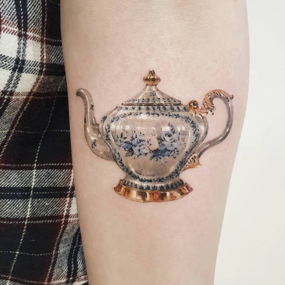 Micro-realistic style teapot tattoo located on the inner forearm.