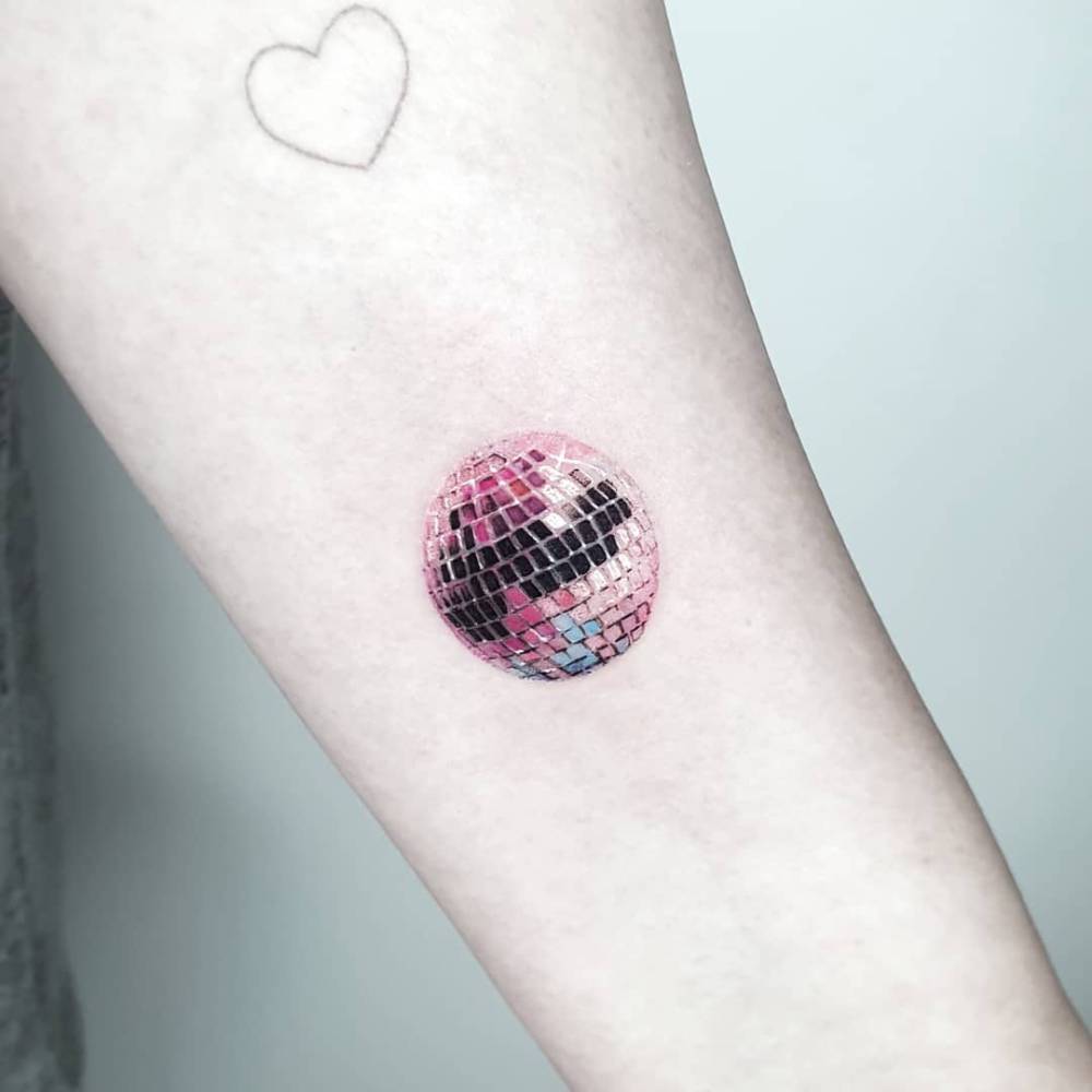 Disco ball tattoo located on the inner forearm, micro-realistic style.