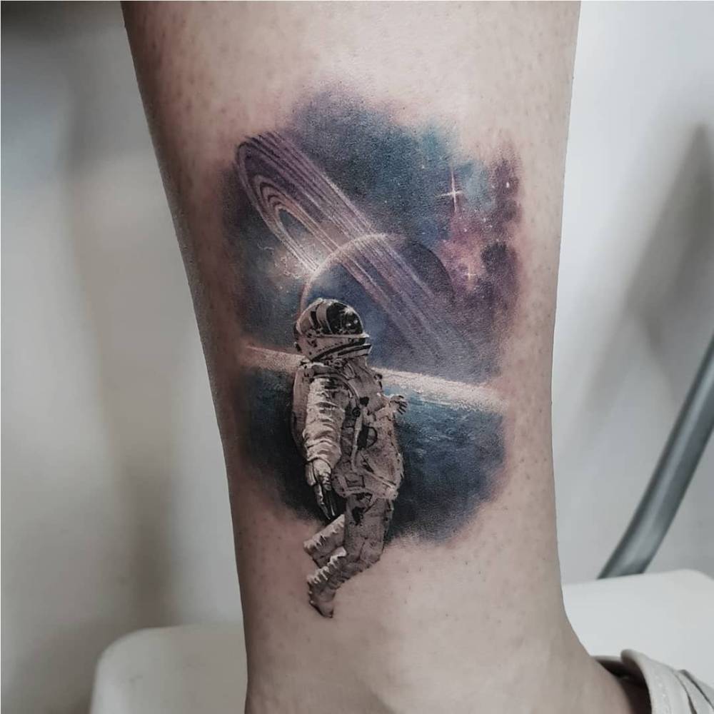 Astronaut tattoo located on the ankle, done in micro-realistic style.