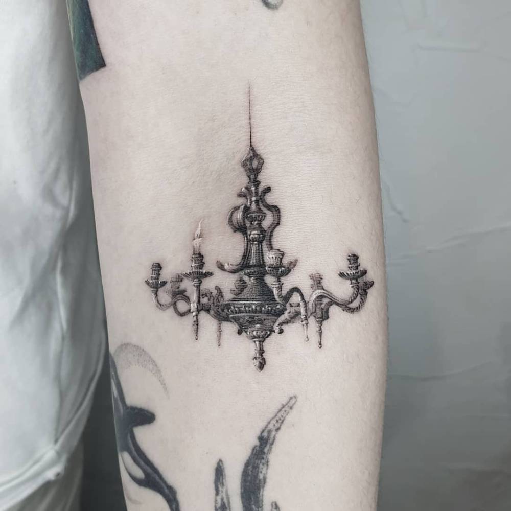 Chandelier tattoo in micro-realistic style located on the inner forearm.