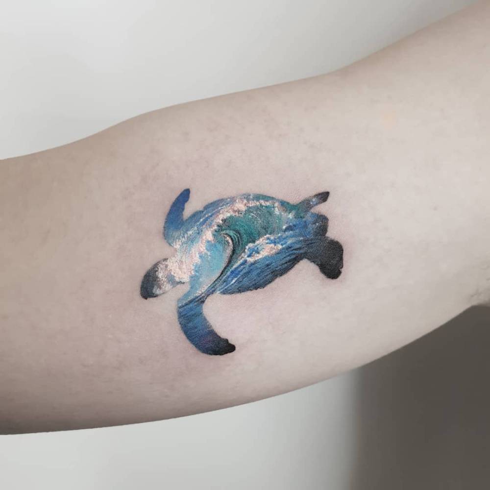 Turtle and waves tattoo located on the inner arm, micro-realistic style.