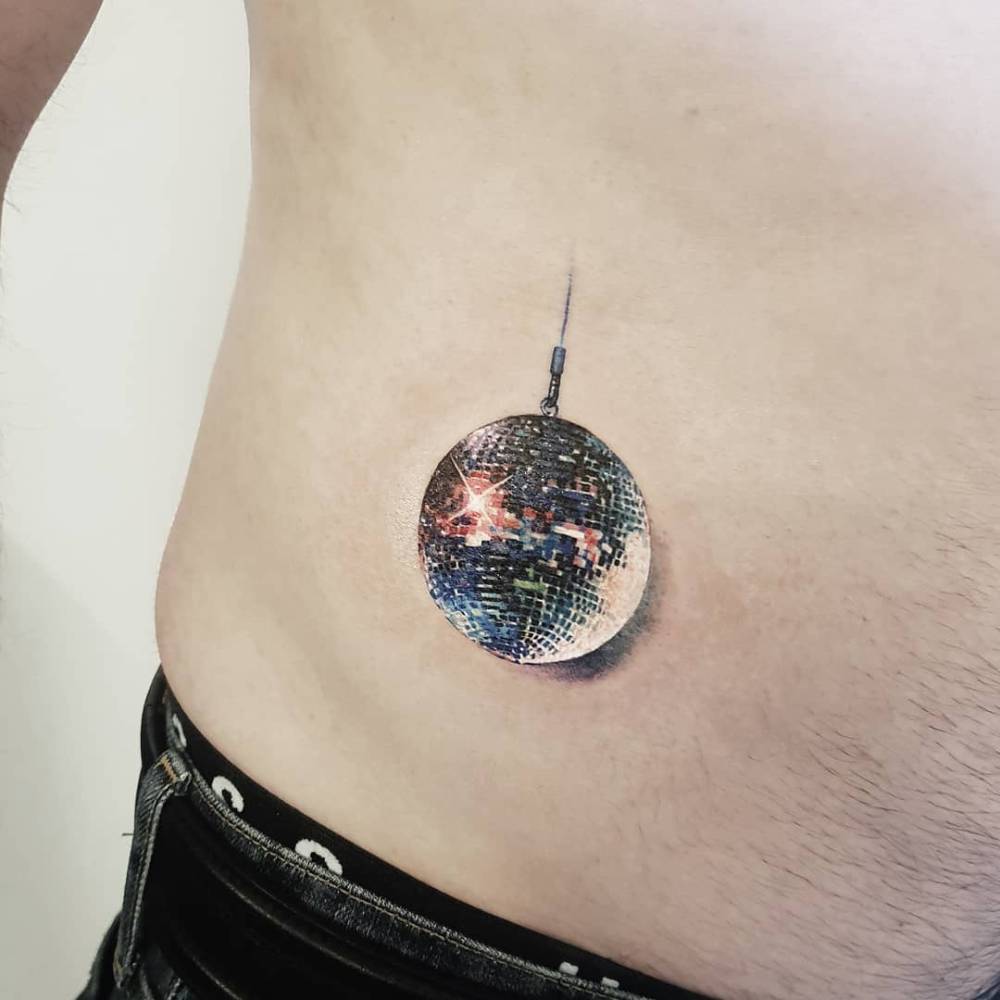 Disco ball tattoo in micro-realism located on the waist.