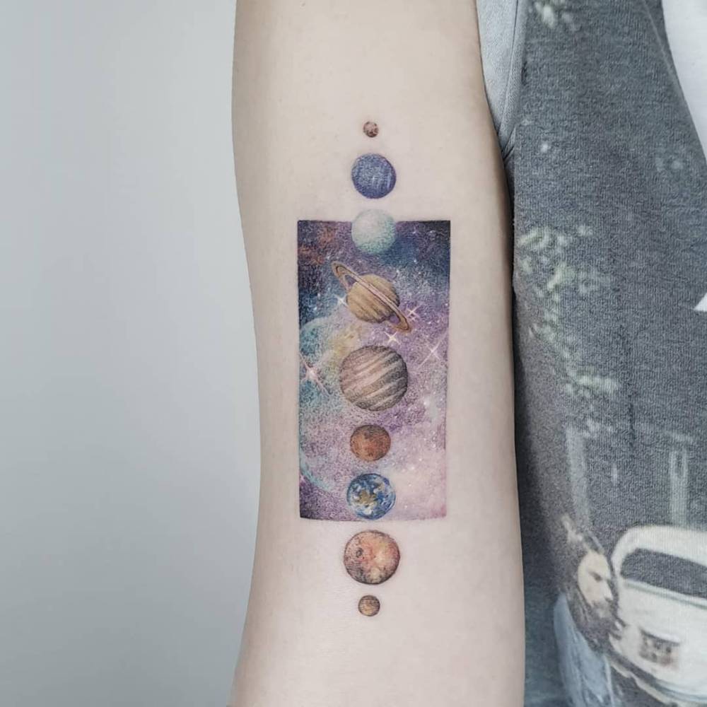 Solar system tattoo in micro-realistic style located on the bicep.