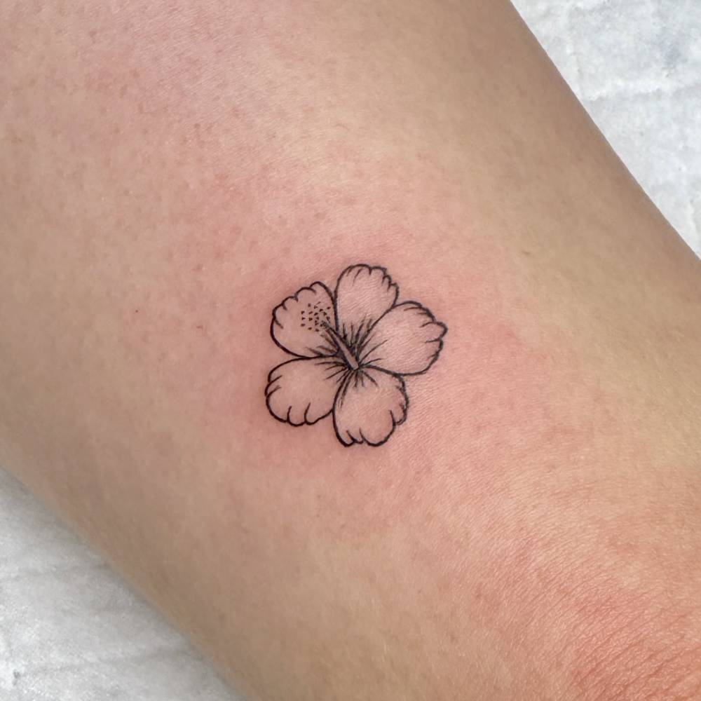 Hibiscus flower tattoo in minimalistic style located on the tricep.