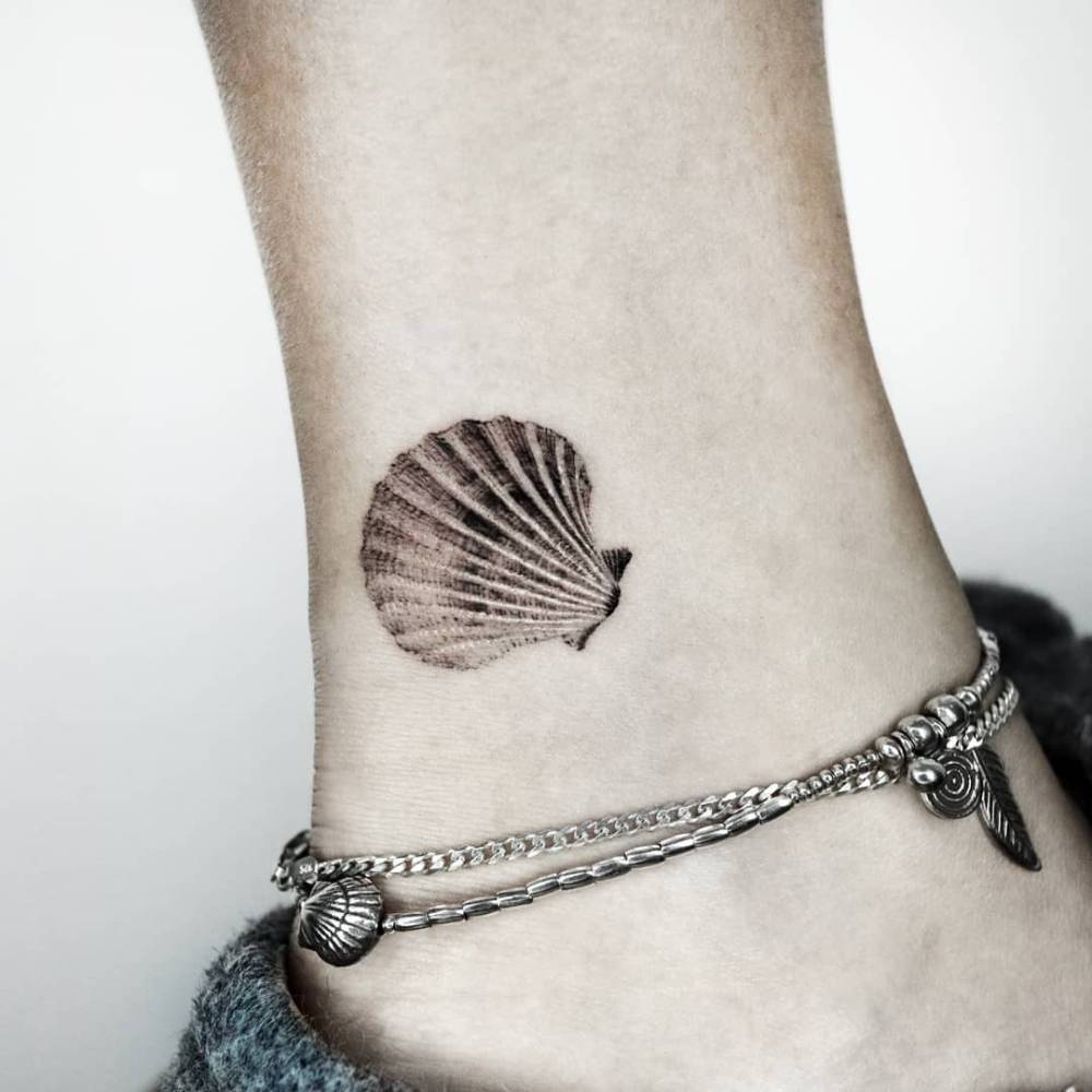 Scallop shell tattoo done on the ankle, micro-realisti style.
