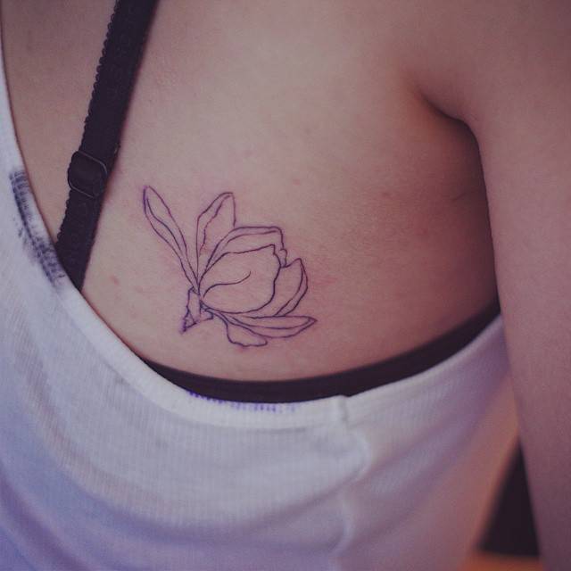 Magnolia tattoo in line art style located on the back.