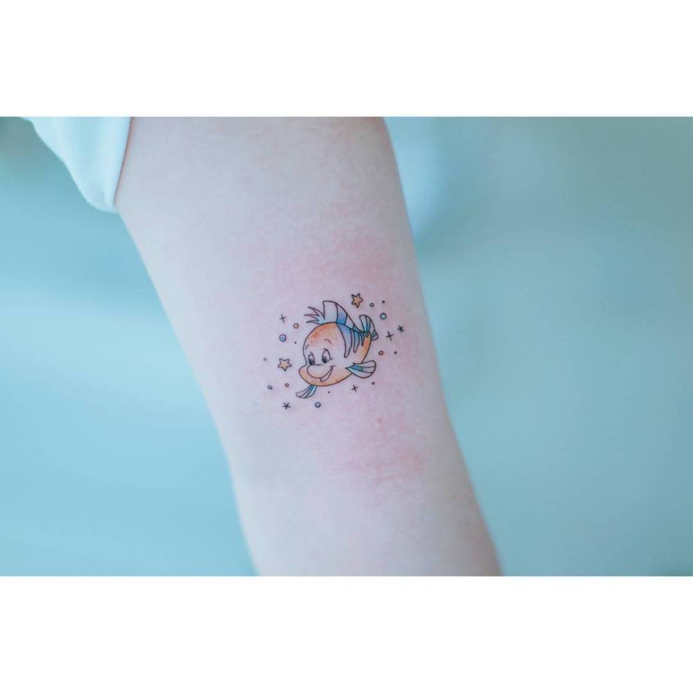 Flounder tattoo in cartoon style placed on the inner arm.