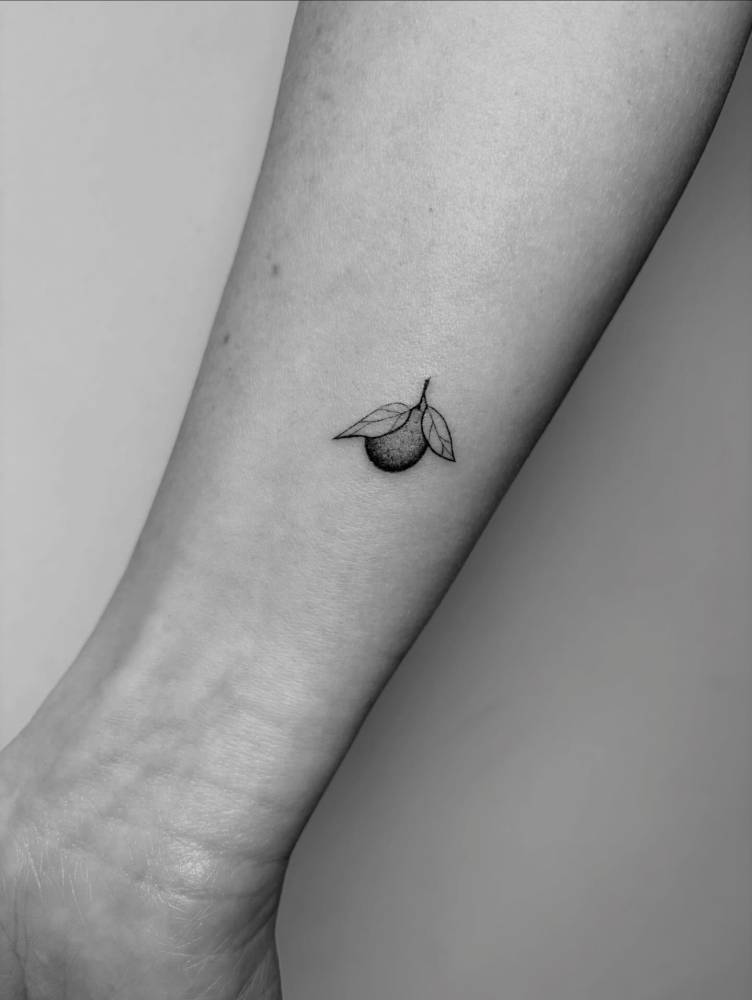 Lemon tattoo in illustrative style located on the wrist.