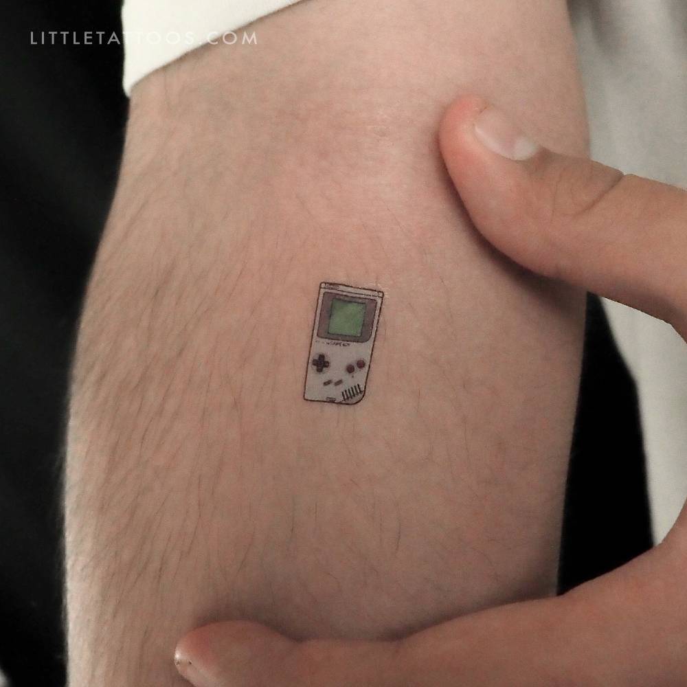 Tiny Game Boy temporary tattoo in illustrative style located on the inner foreartm.