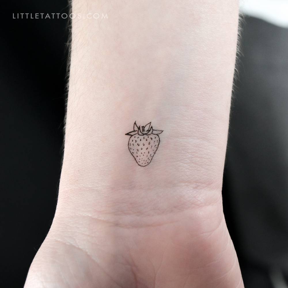 Tiny strawberry temporary tattoo placed on the wrist.