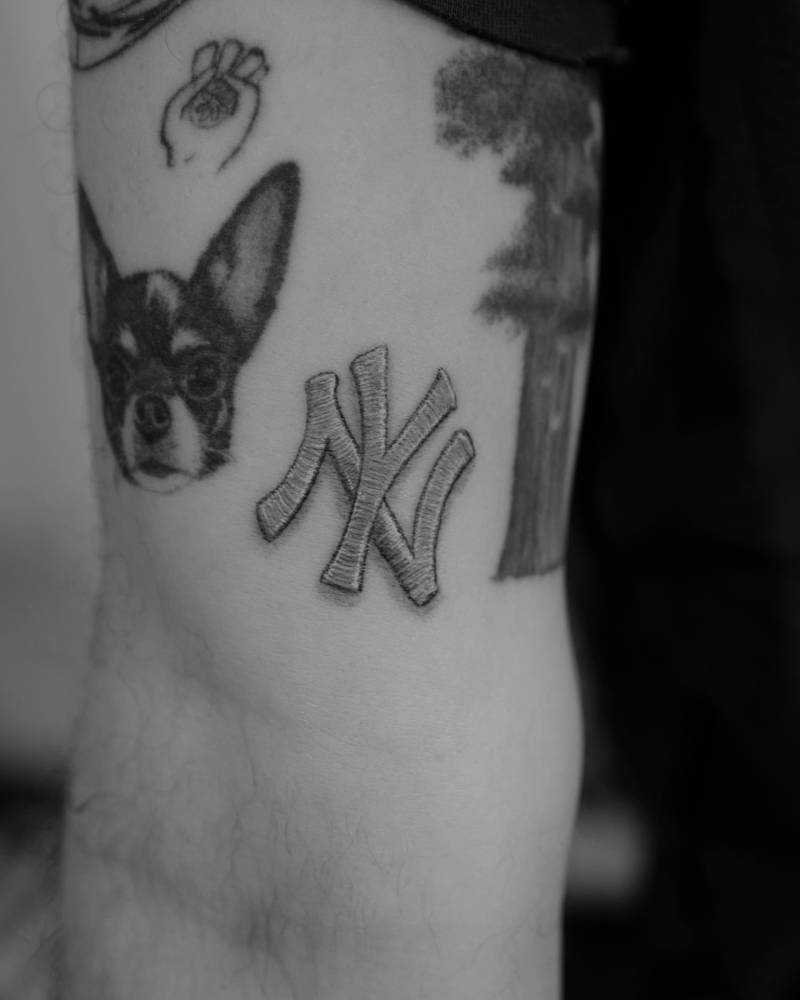 New York Yankees patch tattoo located on the inner arm, embroidery style.
