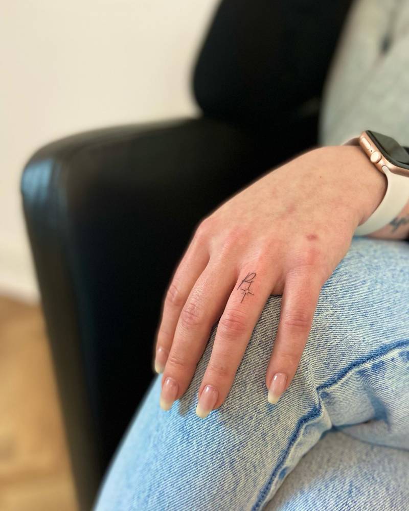 Minimalistic initial and north star tattoo done on the finger.