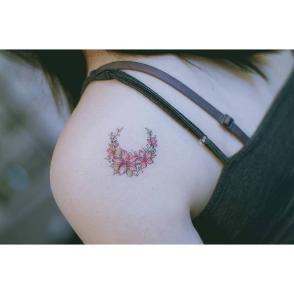 Illustrative style flower moon tattoo placed on the shoulder blade.