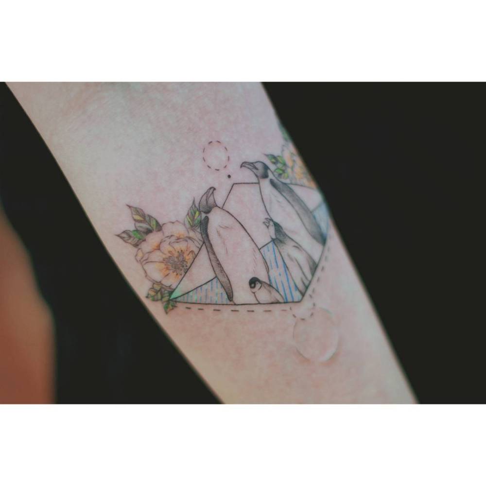 Penguin family tattoo in illustrative style locate on the inner forearm.