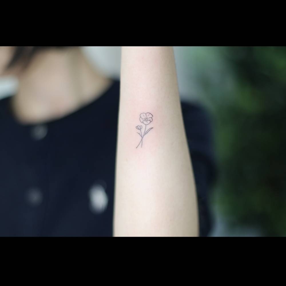 Minimalistic poppy flower tattoo located on the wrist.