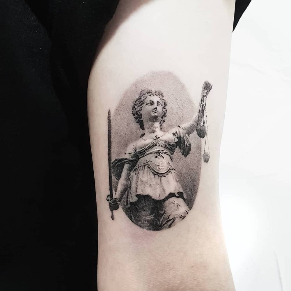 Classical style Lady Justice tattoo located on the bicep.