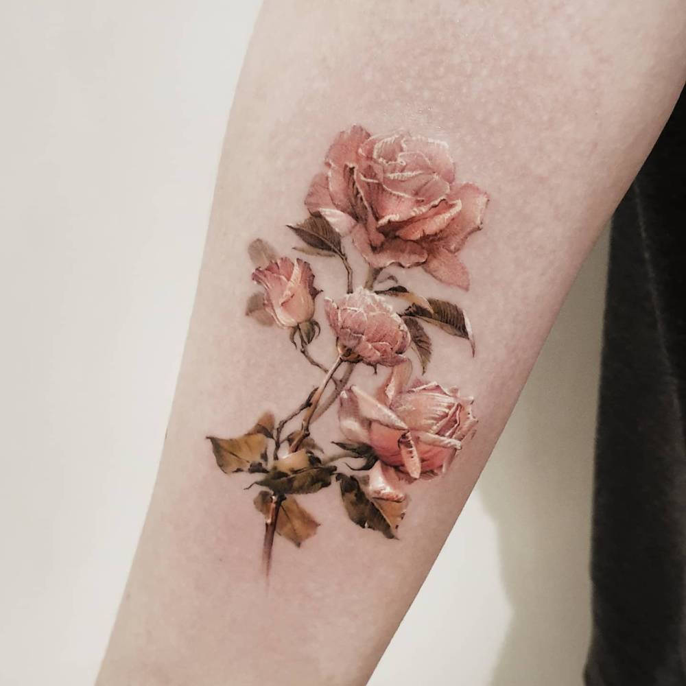 Pink roses tattoo in micro-realistic style placed on the inner forearm.