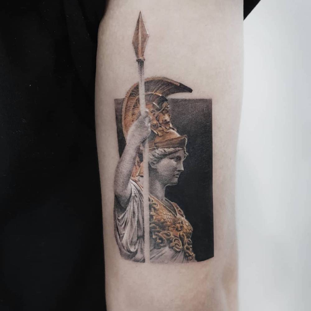 Athena tattoo in micro-realism located on the tricep.