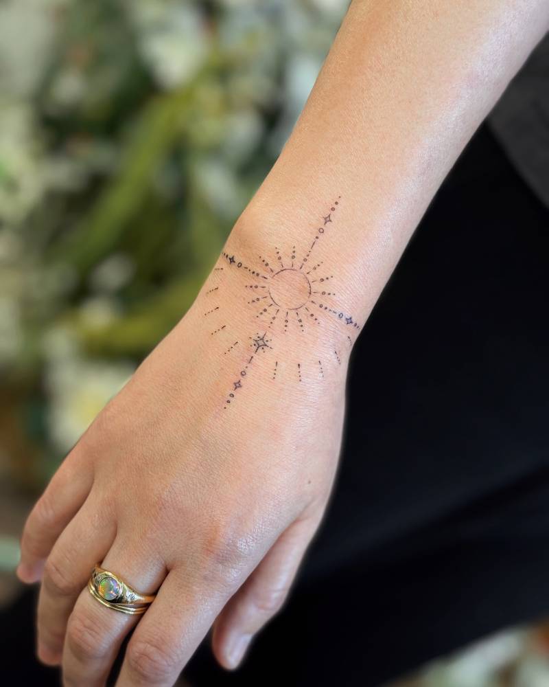 Ornamental tattoo in fine line style placed on the wrist.
