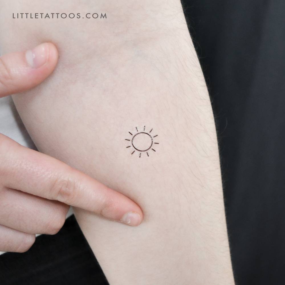 Little minimalist sun temporary tattoo placed on the inner forearm.