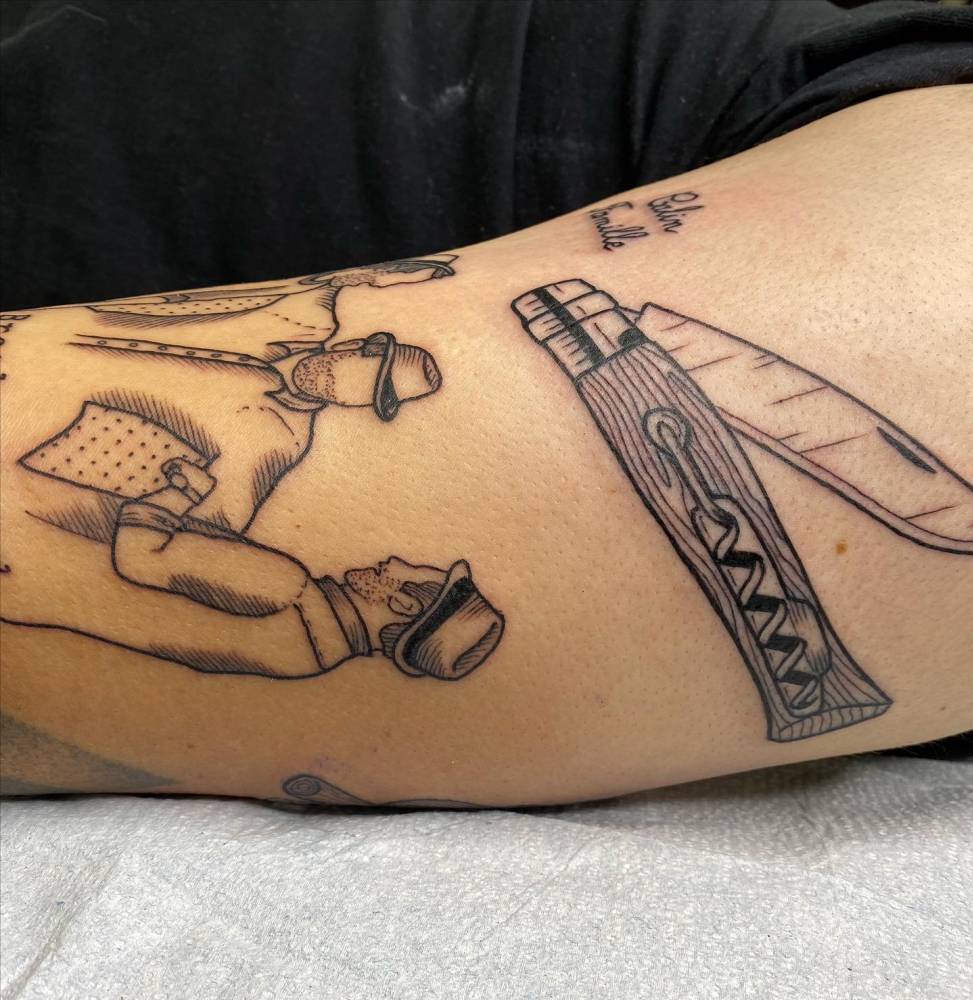 Opinel with corkscrew tattoo located on the upper arm.