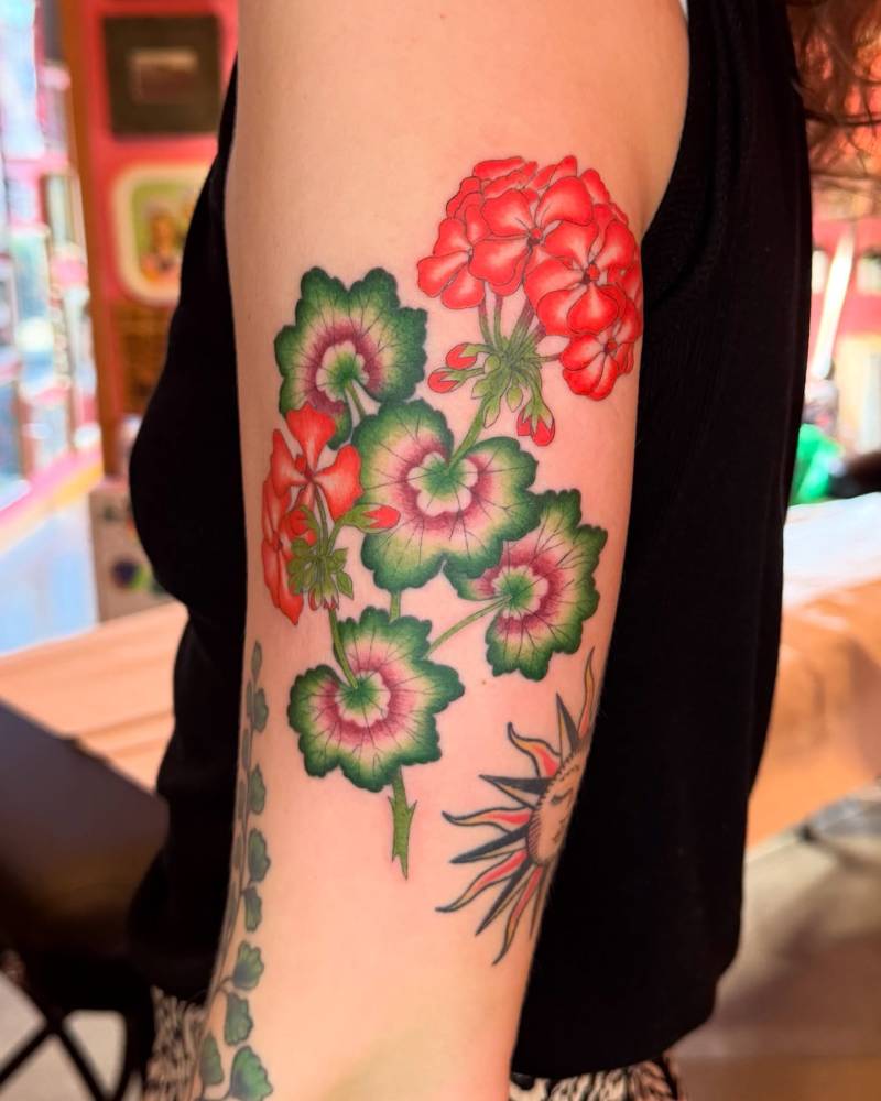 Illustrative style geranium tattoo done on the upper arm.