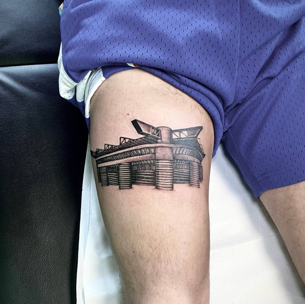 San Siro tattoo located on the thigh, done in illustrative style.