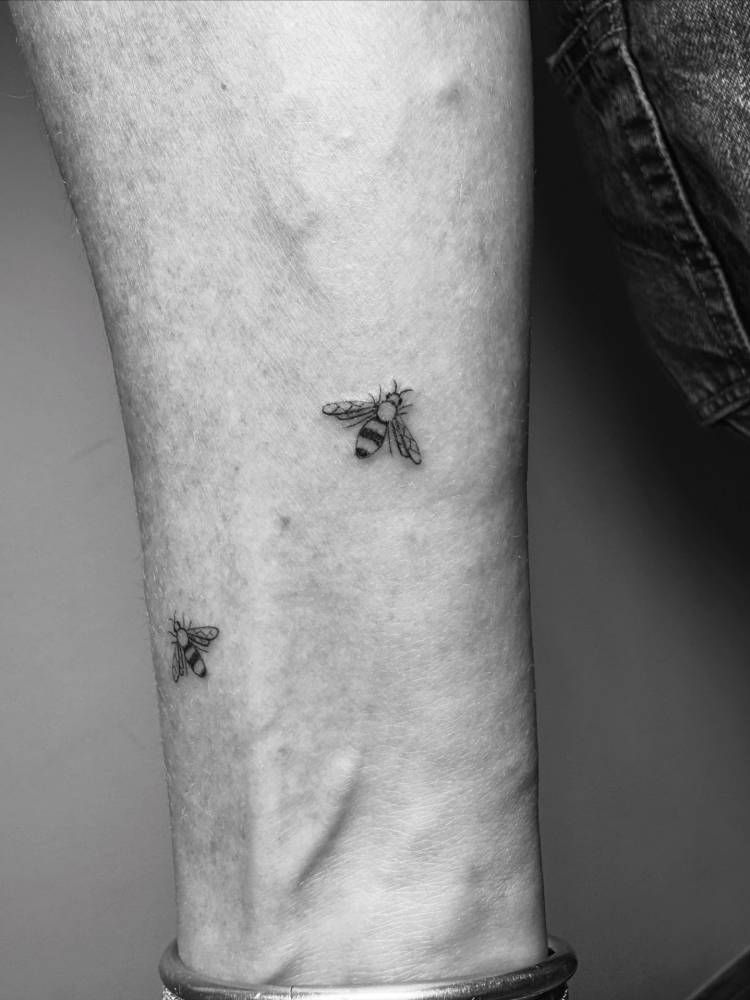 Little bees in illustrative style located on the wrist.