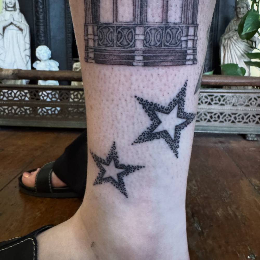 Leopard print stars tattooed on the ankle, illustrative style.