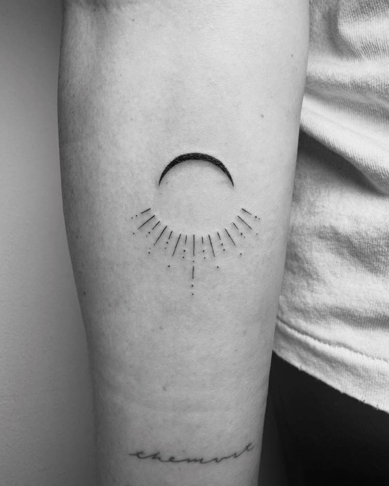 Sun and moon tattoo in minimalistic style located on the inner forearm.