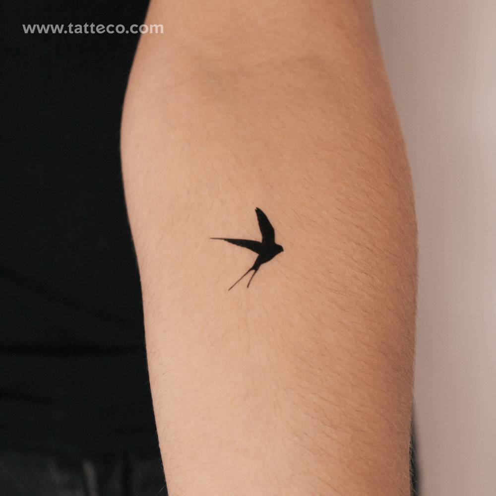 Black swallow semi-permanent tattoo done on the inner forearm.