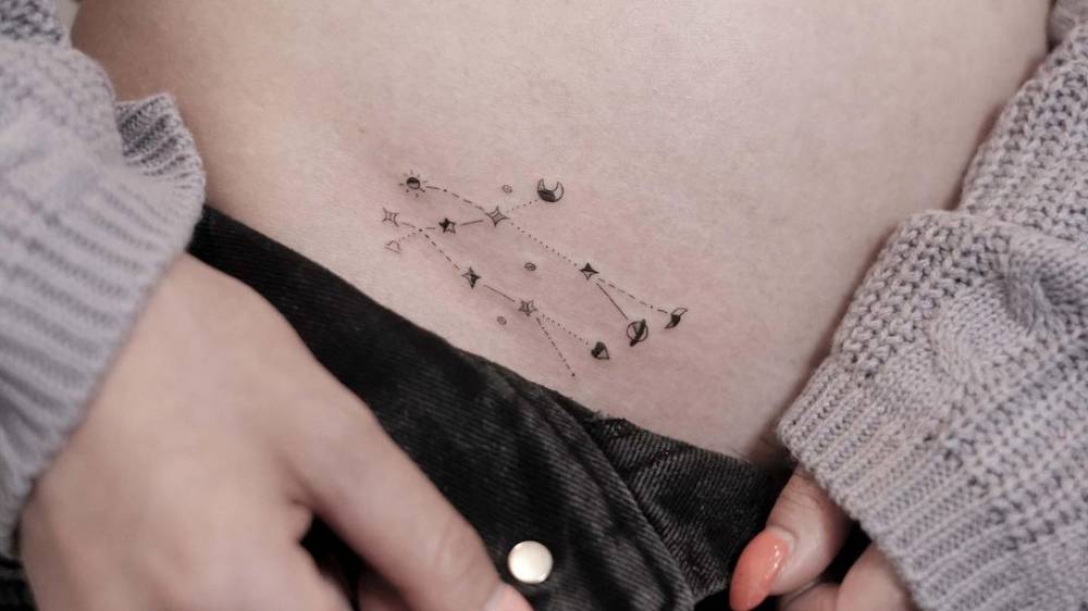 Gemini constellation tattoo located on the pelvis.