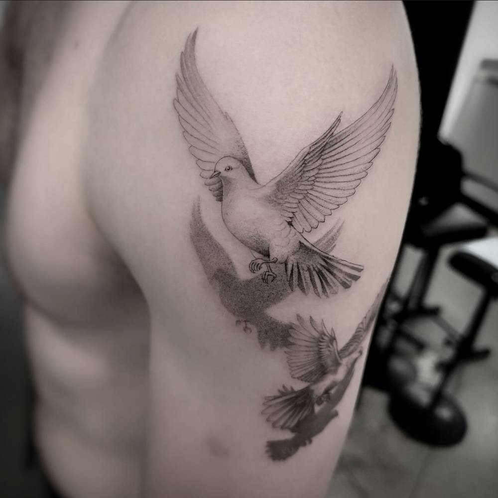 Illustrative style doves tattoo done on the upper arm.