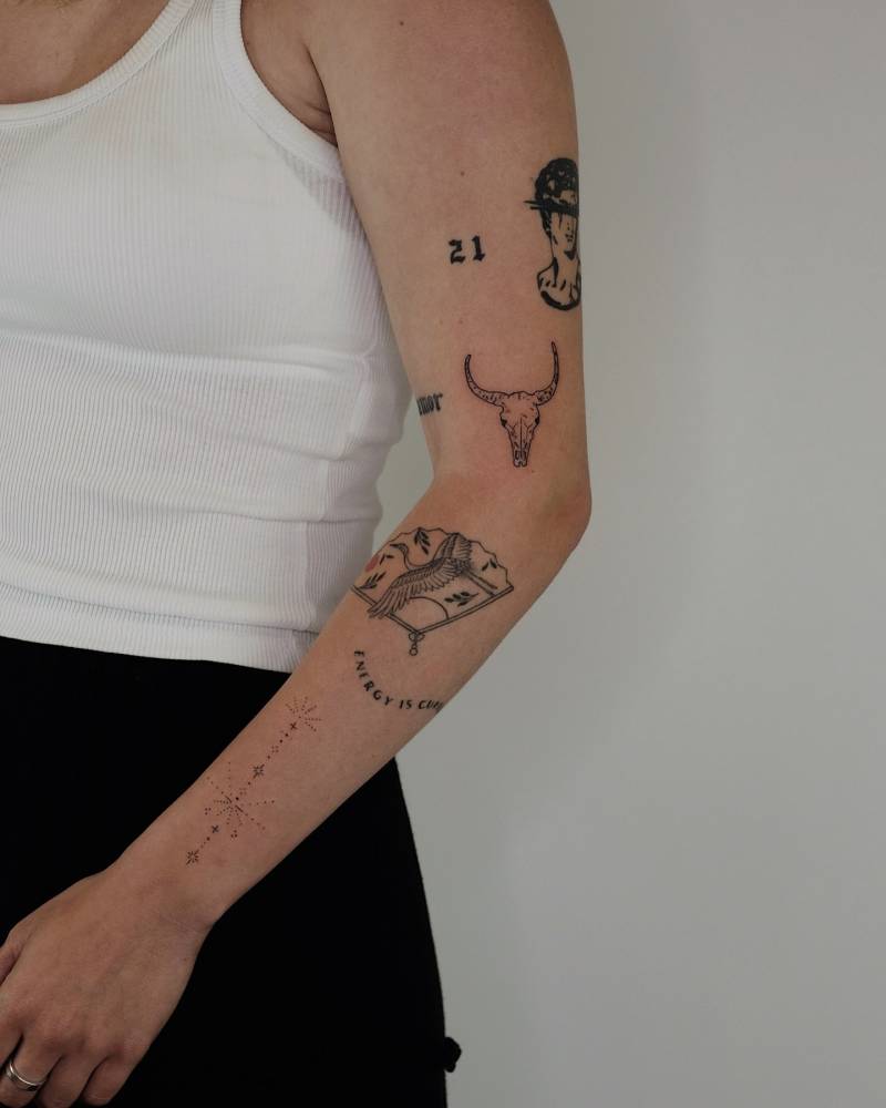 Illustrative style arm composition tattoos with a fresh bull skull tattoo.
