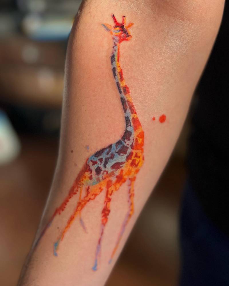 Watercolor style giraffe tattoo done on the inner forearm.