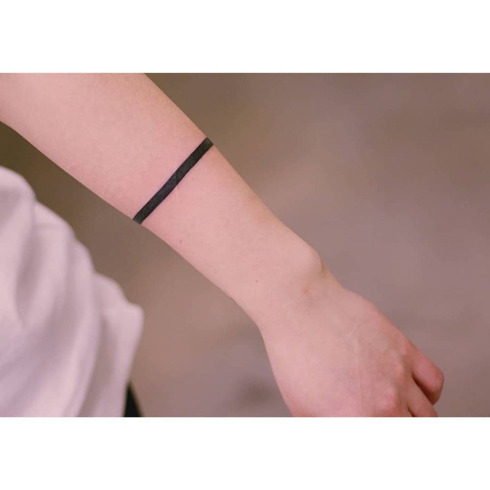 Minimalistic armband tattoo in blackwork style.