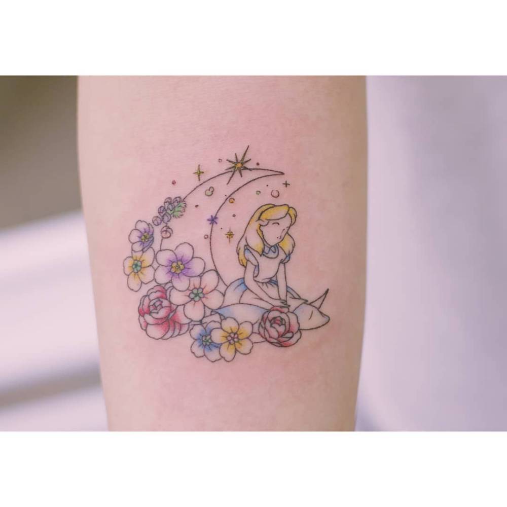Disney's Alice and flower moon tattoo located on the inner forearm.